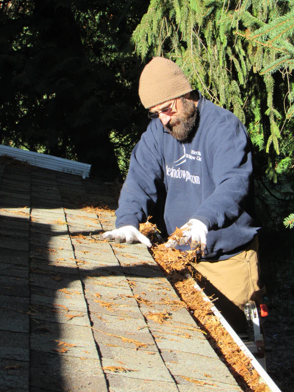 man cleaning roof gutter