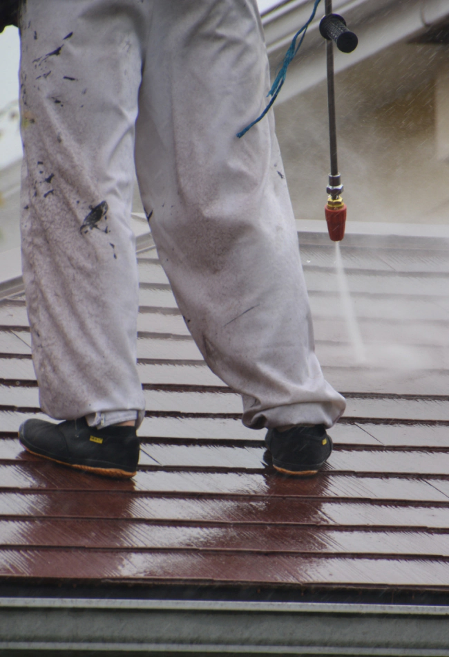 man cleaning roof using pressure washing service